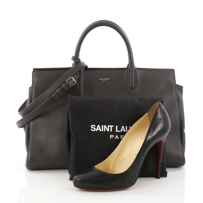 This authentic Saint Laurent Rive Gauche Cabas Leather Medium is a sleek yet elegant bag synonymous with the brand's classic aesthetic. Crafted from taupe leather, this sought-out tote features a Saint Laurent embossed signature at the front,