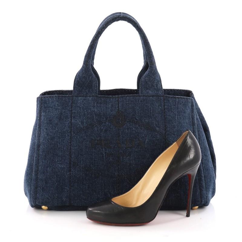 This authentic Prada Canapa Tote Denim Small is classic and sophisticated perfect for everyday casual look. Crafted in blue denim, this tote features dual handles, embossed Prada logo at the center, side snap buttons, and gold-tone hardware accents.