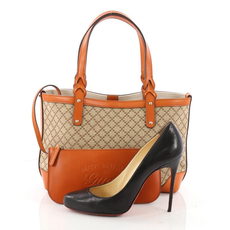 This authentic Gucci Craft Tote Diamante Canvas Small is casual and stylish perfect for everyday use. Crafted from brown diamante canvas with orange leather trims, this tote features dual-flat handles with braided ends and gold-tone hardware