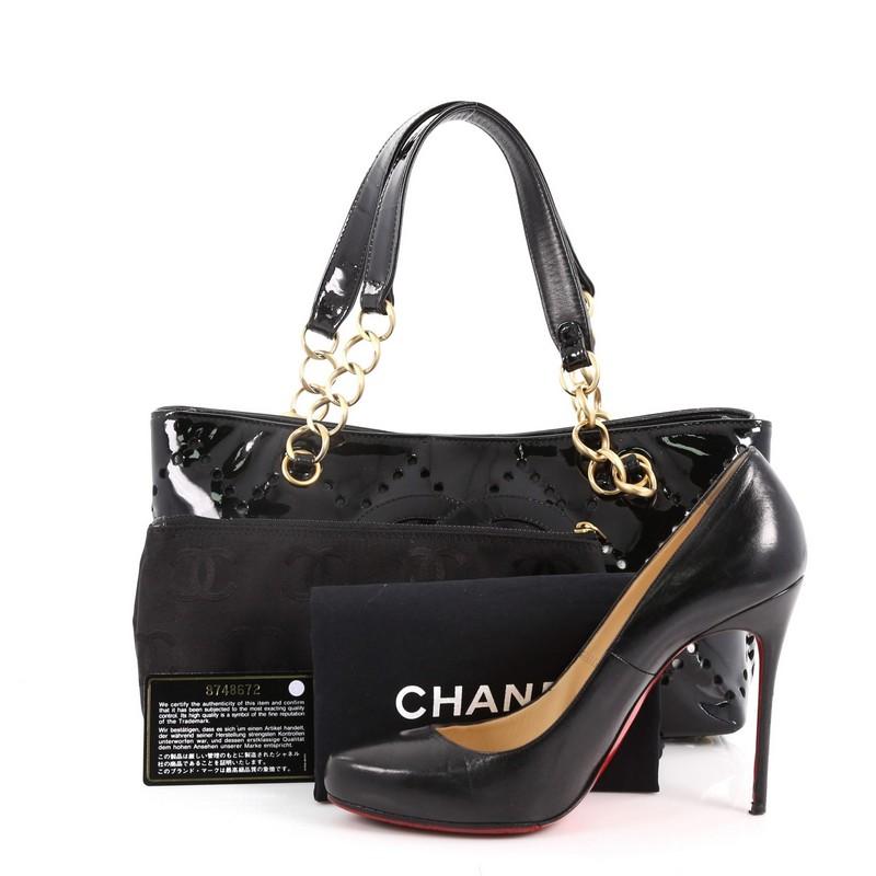 This authentic Chanel CC Chain Tote Perforated Patent Small is sophisticated and elegant in design made for everyday excursions. Crafted from black patent leather, this tote features dual flat top handles with gold-tone chain links, perforations in