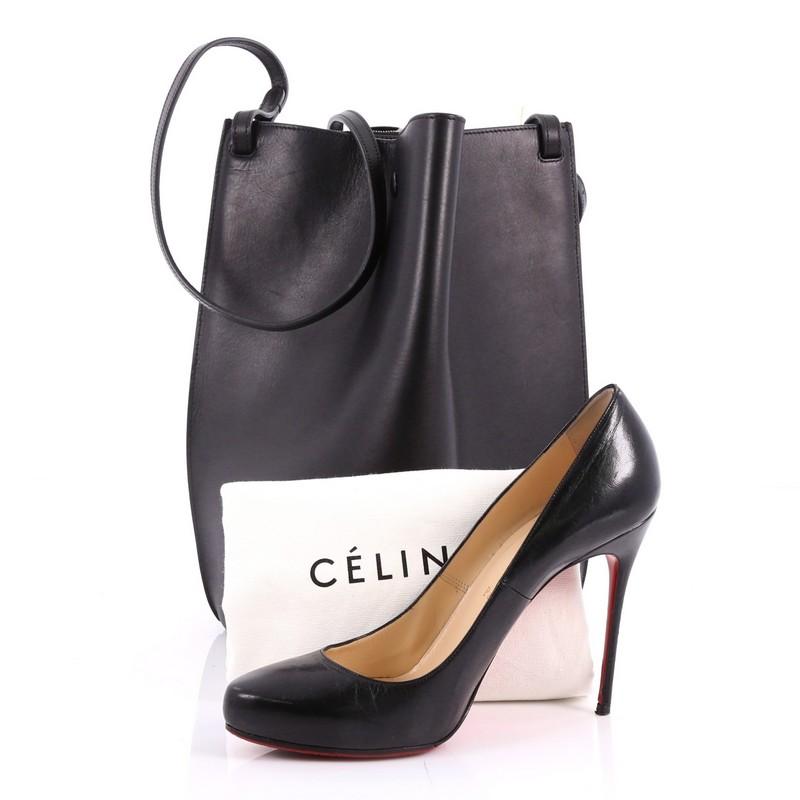 This authentic Celine Pinched Bag Leather Medium is an understated, minimalist bag made for everyday use. Crafted from black leather, this miniature bucket bag features an adjustable shoulder strap, sturdy base and gold-tone hardware accents. Its
