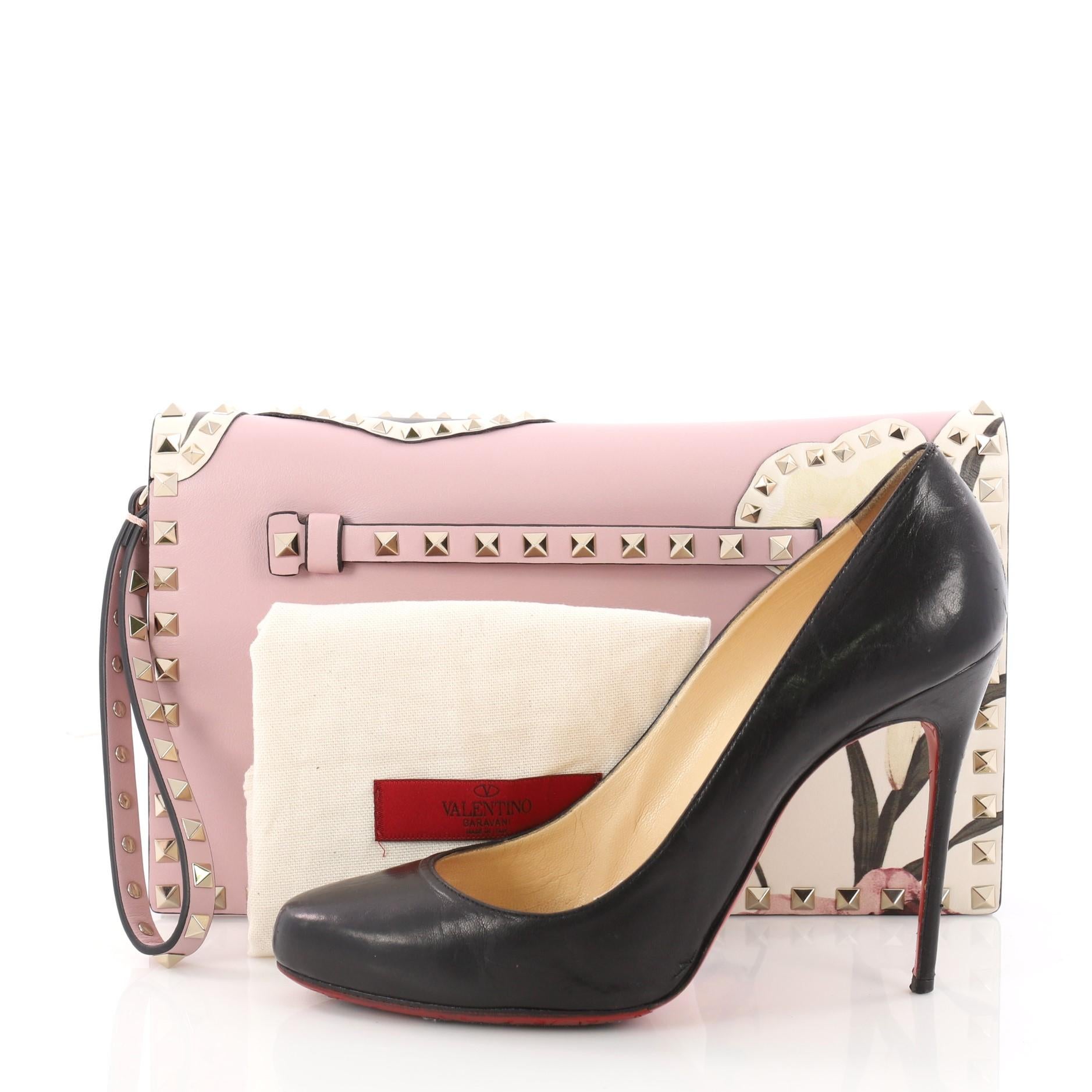 This authentic Valentino Rockstud Flap Clutch Patchwork Leather is a chic yet functional accessory perfect for on-the-go moments. Crafted from pink leather, this trendy clutch features polished gold Valentino signature rockstuds detailing, lasercut