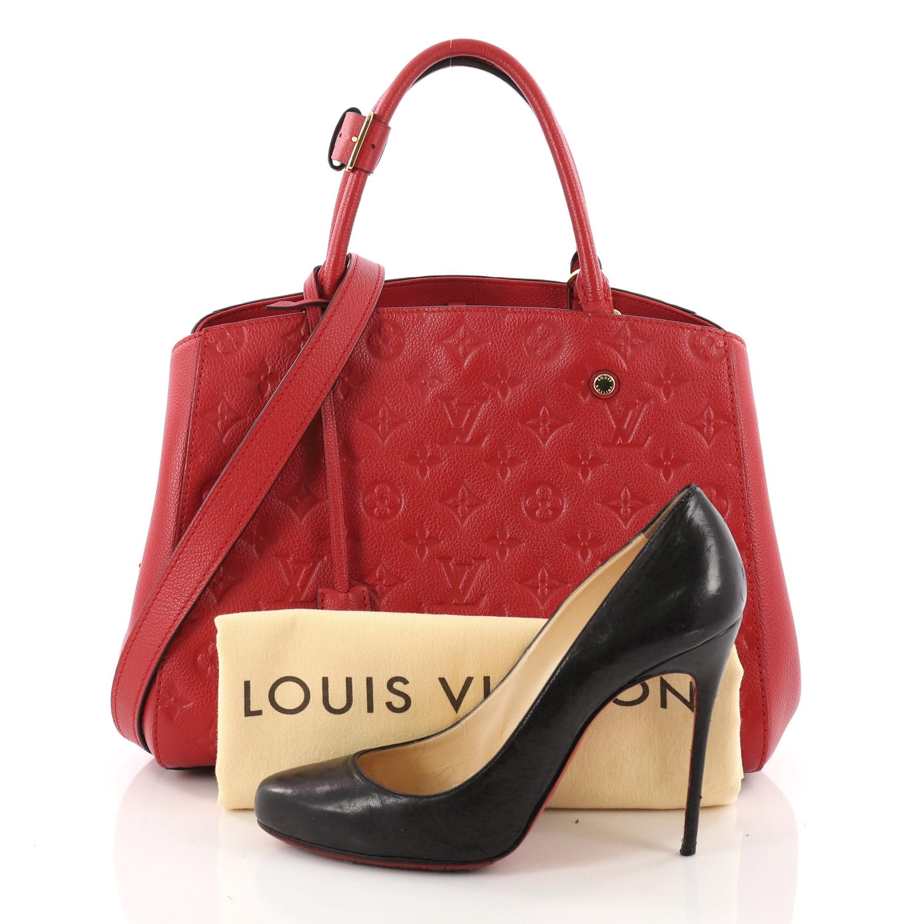 This authentic Louis Vuitton Montaigne Handbag Monogram Empreinte Leather MM is as sophisticated as it is sturdy. Crafted in red monogram empreinte leather, this luxurious and refined bag features dual-rolled leather handles, protective base studs