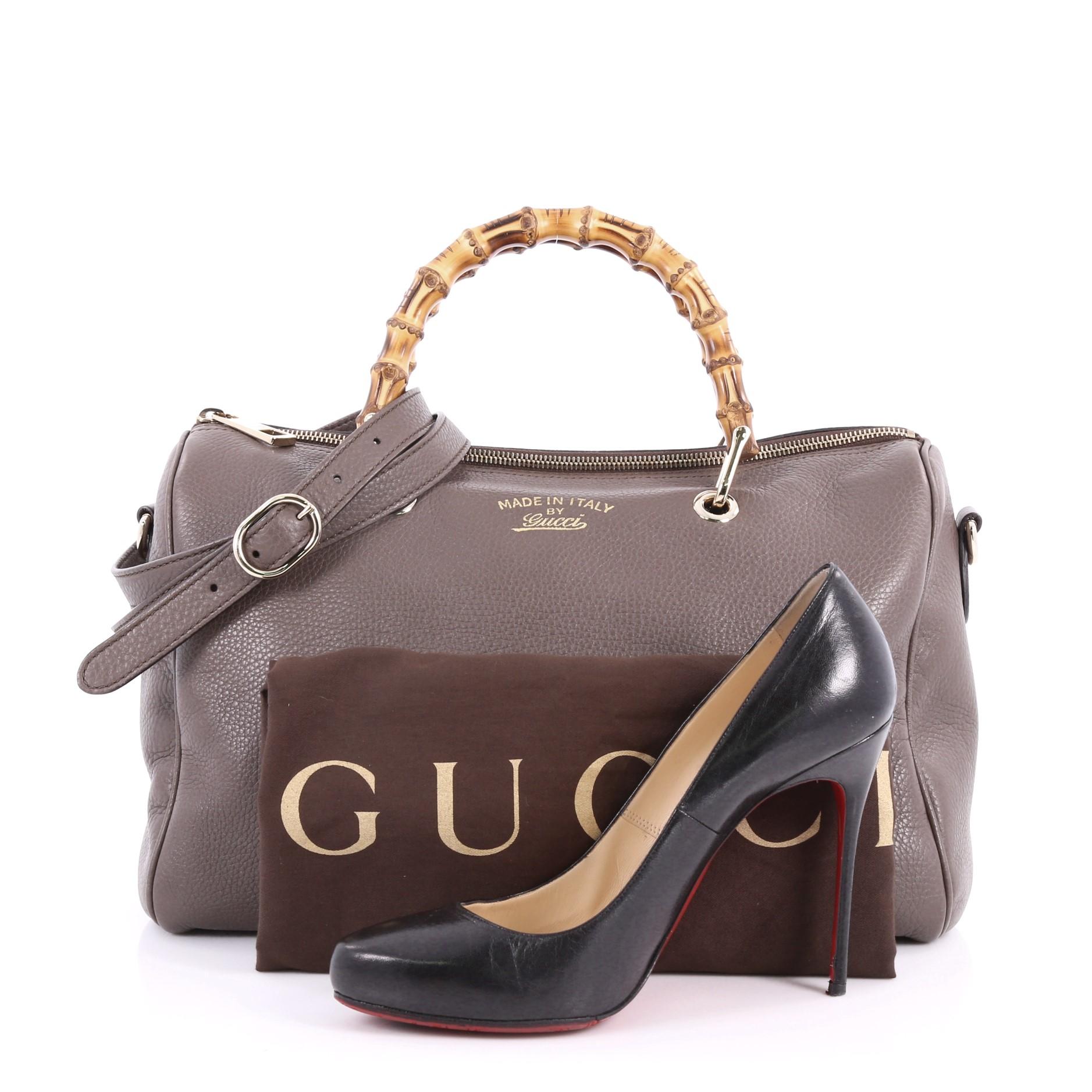This authentic Gucci Bamboo Shopper Boston Bag Leather Medium is a classic must have. Crafted from taupe leather, this simple yet stylish bag features Gucci's signature sturdy bamboo handles, protective base studs, stamped logo at the front, and