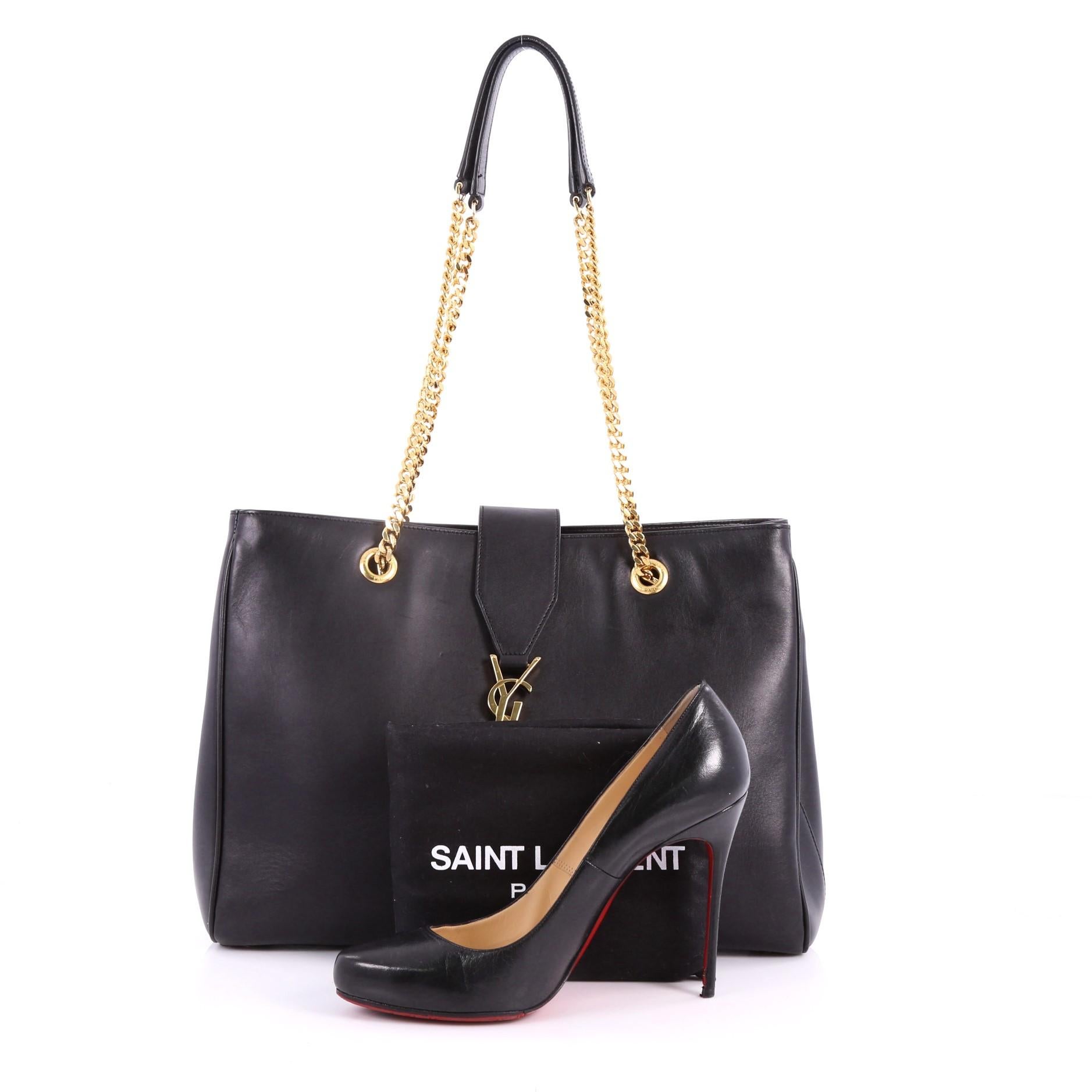 This authentic Saint Laurent Classic Monogram Shopper Leather Large is stylish and elegant in design perfect for the modern fashionista. Crafted from black leather, this bag features dual gold-tone chain straps, signature interlocking gold-tone YSL