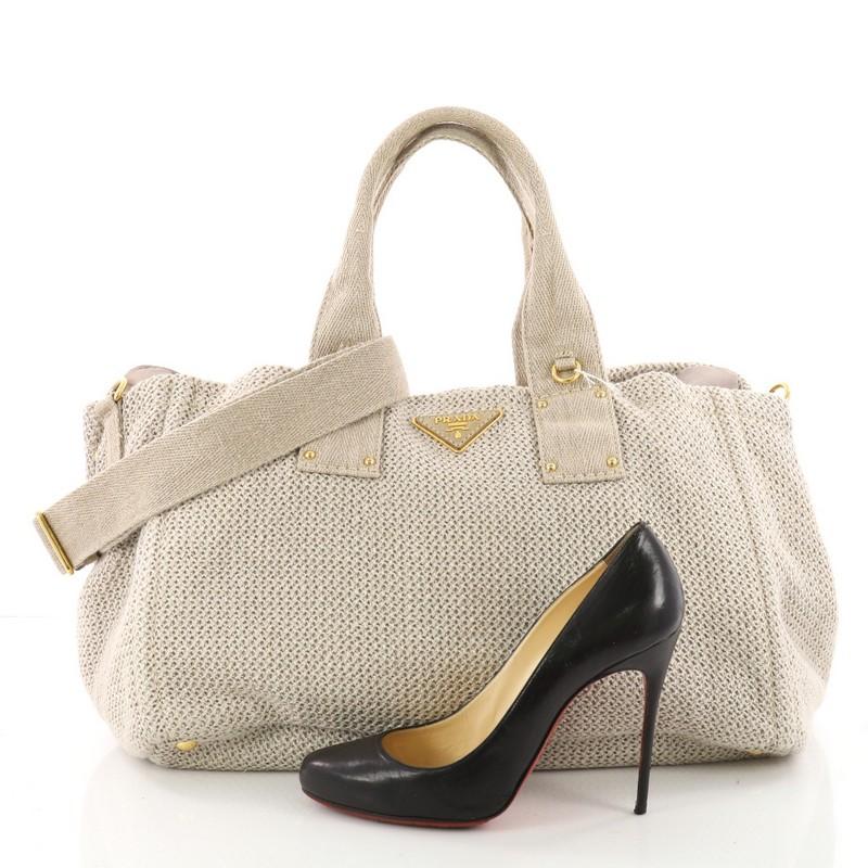 This authentic Prada Convertible Open Tote Raffia Large is a simple yet luxurious bag perfect for everyday use. Crafted in cream raffia, this chic casual tote features a signature Prada logo at the center, dual-rolled raffia handles, side snap