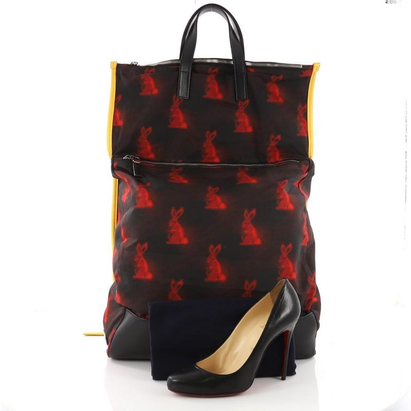 This authentic Prada Convertible Backpack Printed Tessuto is a trendy and stylish bag perfect for fashionistas on-the-go. Crafted from black printed tessuto fabric, this backpack features dual flat leather handles on a fold-over top, adjustable