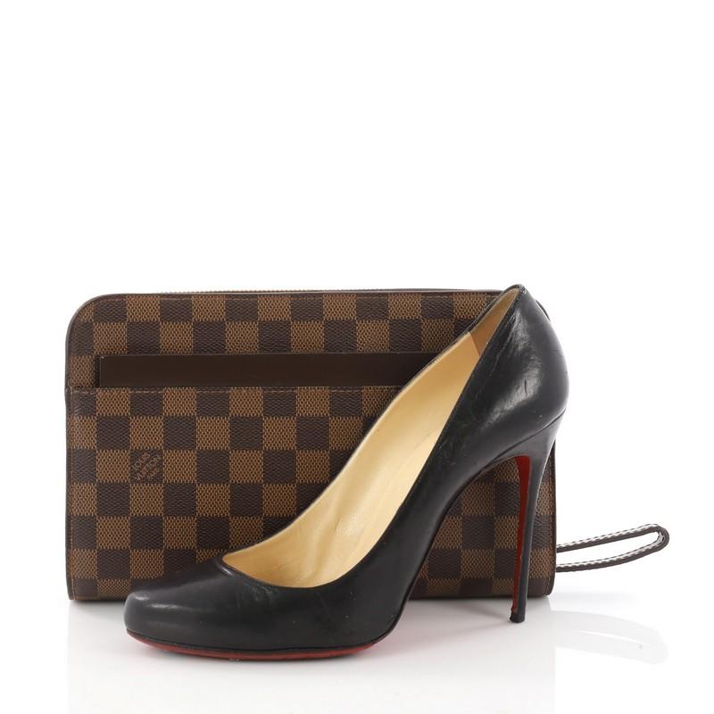 This authentic Louis Vuitton Pochette Saint Louis Damier is perfect for any casual or sophisticated outfit. Crafted from brand's iconic Damier Ebene coated canvas and brown leather, this simplistic clutch features a flat pocket, retractable wrist