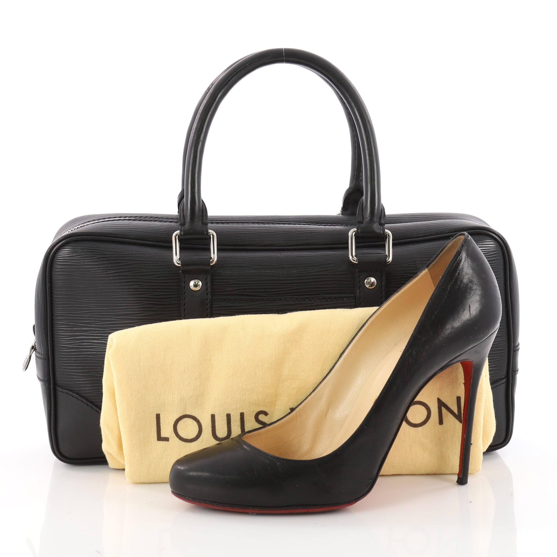 This authentic Louis Vuitton Vivienne Handbag Epi Leather East West is for an accent of luxury and style. Crafted in black epi leather, this bag features dual-rolled leather handles, exterior slip pocket and silver-tone hardware accents. It opens to