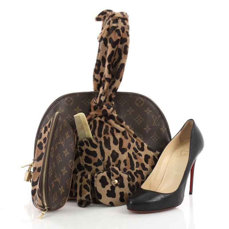 This authentic Louis Vuitton Limited Edition Alaia Centenaire Alma Bag Pony Hair and Monogram Canvas is a limited edition from the Centenaire 100th Anniversary Collection by designer Azzedine Alaïa. Crafted in leopard print brown pony hair and