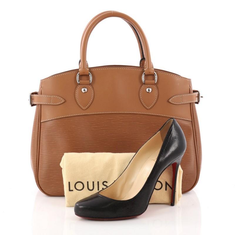 This authentic Louis Vuitton Passy Handbag Epi Leather PM is an understated yet elegant bag with a sophisticated look. Crafted from Louis Vuitton's signature epi leather in brown, this bag features silver-tone hardware accents, side belt strap