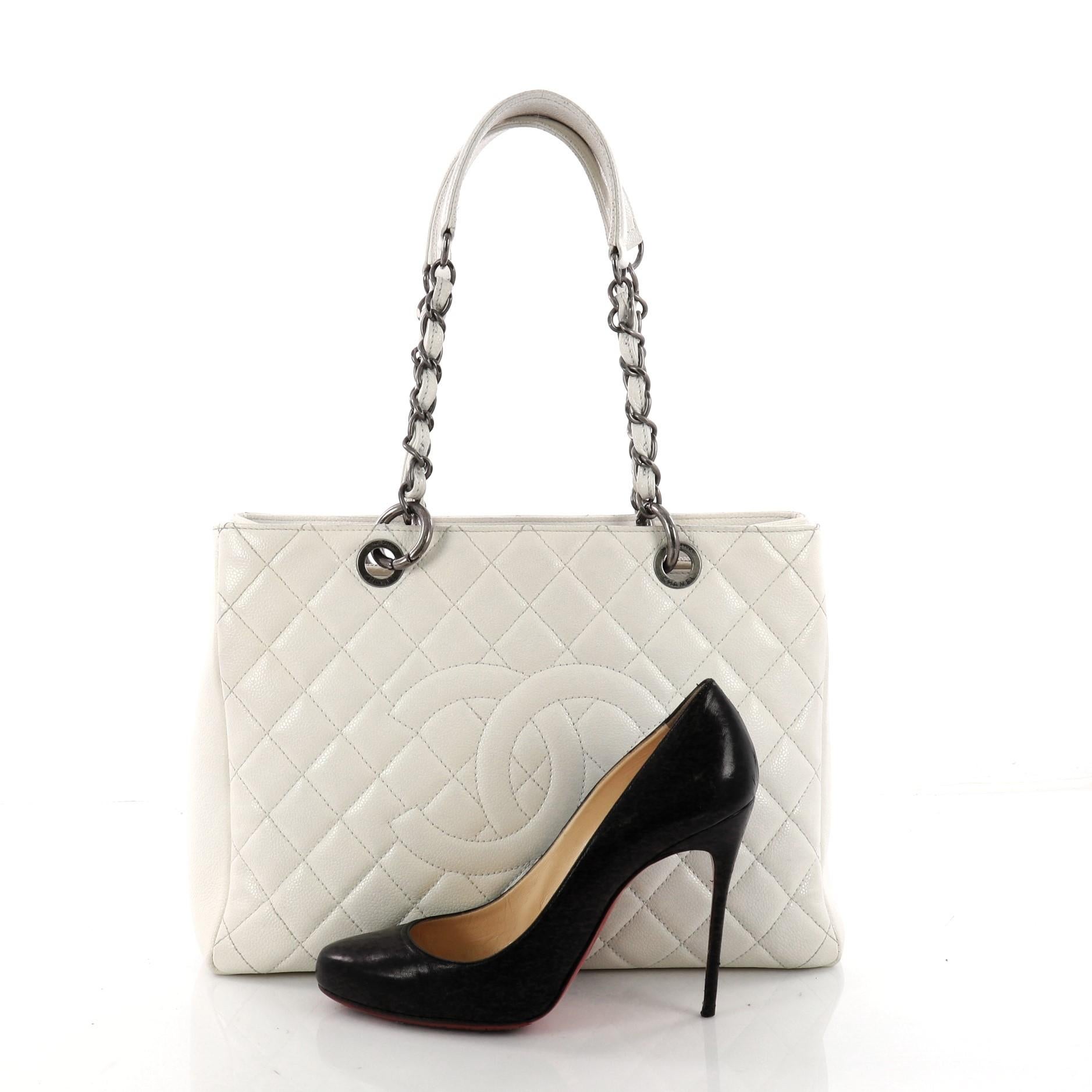 This authentic Chanel Grand Shopping Tote Quilted Caviar is perfect for everyday use with a classic yet luxurious style. Crafted in white diamond quilted caviar leather, this timeless tote features a stitched CC in the middle, woven-in leather chain