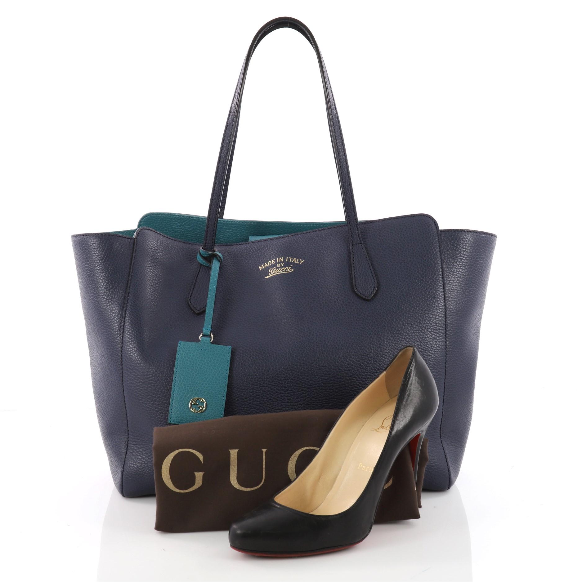 This authentic Gucci Swing Tote Leather Medium is modern and sophisticated in design. Crafted in blue leather, this elegant tote features tall dual-slim handles, Gucci stamped logo at the front, expanded wing silhouette, and gold-tone hardware