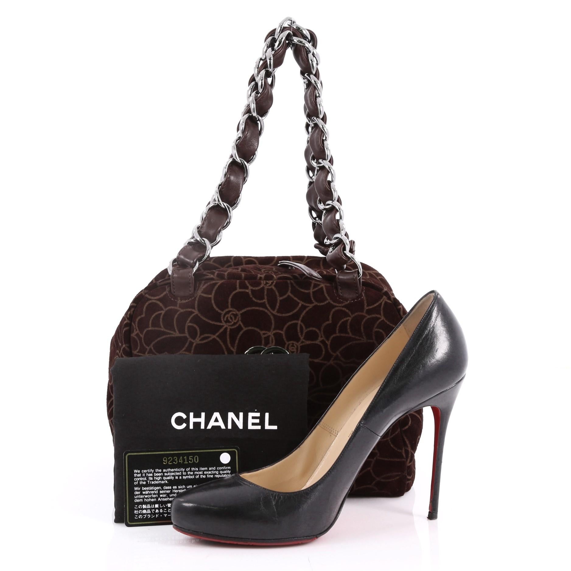 This authentic Chanel Vintage Camellia Bowling Bag Embossed Suede Small is a classic design is perfect for everyday looks. Crafted in brown embossed suede, this bag features large woven-in leather chain straps, embossed Camellia design, CC logo at