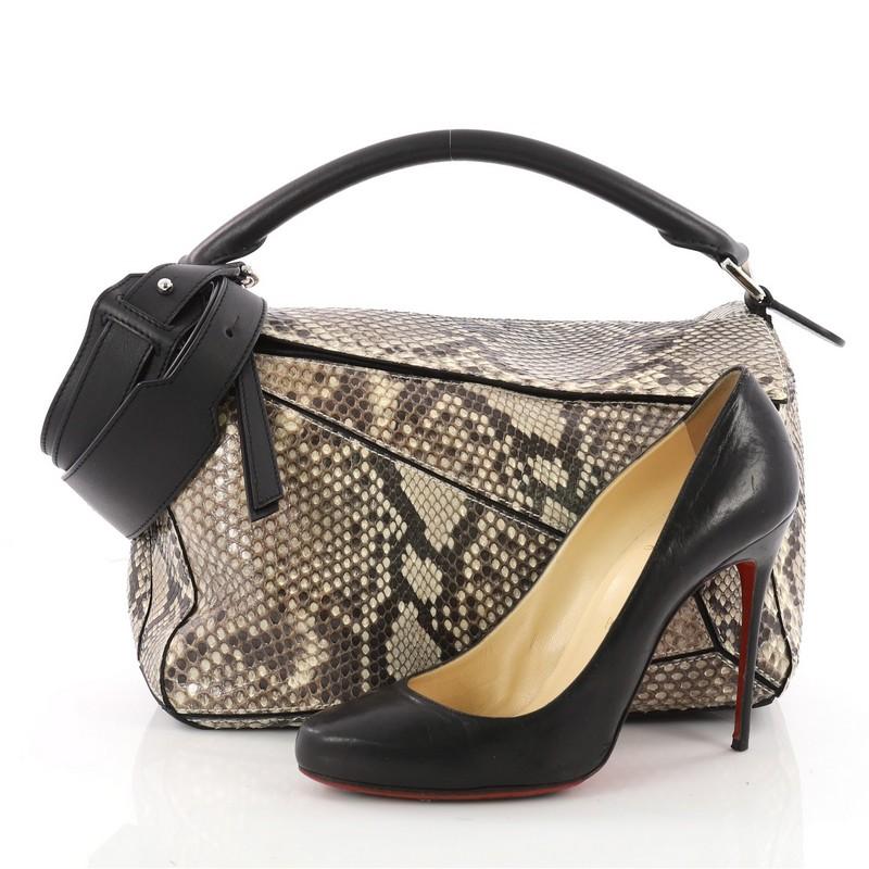 This authentic Loewe Puzzle Bag Python Medium showcases a unique pliable design that folds into five different shapes. Crafted in genuine brown python, this versatile bag features rolled top handle, protective metal feet, and silver-tone hardware