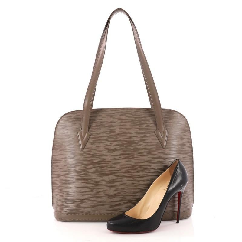 This authentic Louis Vuitton Lussac Handbag Epi Leather is a chic and sophisticated bag perfect for your everyday use. Constructed with Louis Vuitton's signature sturdy taupe epi leather, this bag features dual flat leather straps, subtle LV logo, a