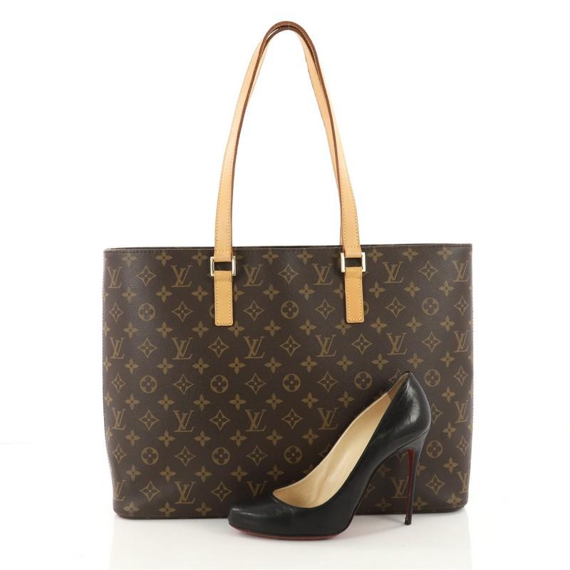 This authentic Louis Vuitton Luco Handbag Monogram Canvas is a classic tote that displays fashion and functionality all rolled into one. Crafted with the brand's iconic brown monogram coated canvas, this tote features dual flat leather handles, a