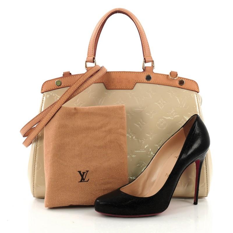 This authentic Louis Vuitton Brea Handbag Monogram Vernis MM is a staple for an everyday casual look. Crafted in citrine monogram vernis leather with cowhide leather trims, this structured yet feminine tote features dual flat handles, protective