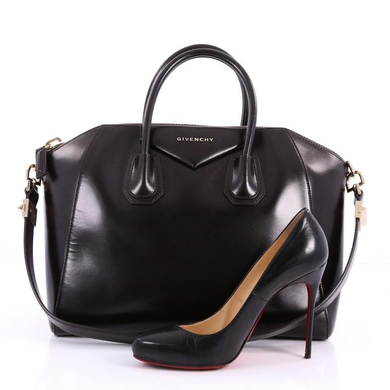 This authentic Givenchy Antigona Bag Glazed Leather Medium combines style and functionality all-in-one. Crafted from sleek dark brown glazed leather, this structured handle bag features a dual-rolled leather handle, the brand's signature envelope