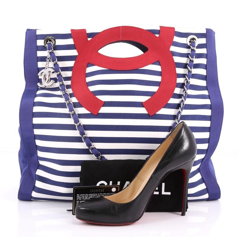 This authentic Chanel Mariniere Chain Tote Striped Canvas Large is from the brand's 2010 Cruise collection. Crafted in red, white and blue striped canvas, this bag features dual chain-link shoulder strap, cutout top handles, interior zip and wall