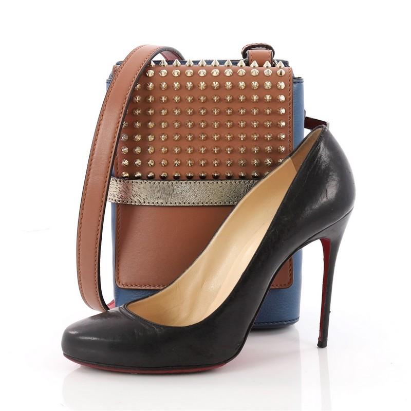 This authentic Christian Louboutin Benech Reporter Bag Spiked Leather is a modern fashionista's everyday companion. Crafted in brown and blue spiked leather, this two-in-one bag features a leather shoulder strap and dual compartments, one that zips