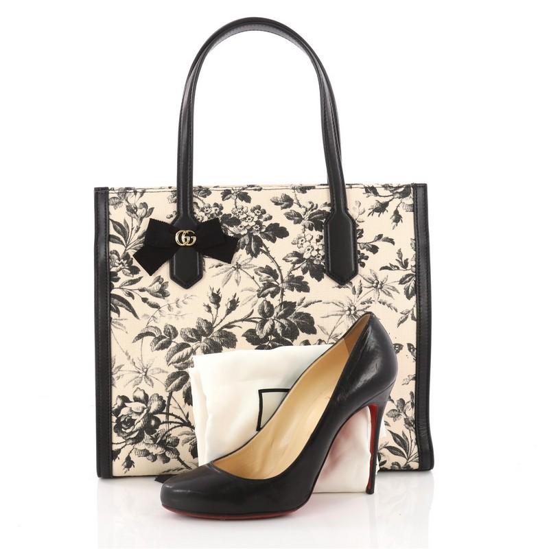 This authentic Gucci GG Ribbon Tote Coated Printed Canvas Medium is a chic and classic accessory made for everyday use. Crafted from printed off-white and black coated canvas, this bag features dual flat leather handles, black leather trims, GG