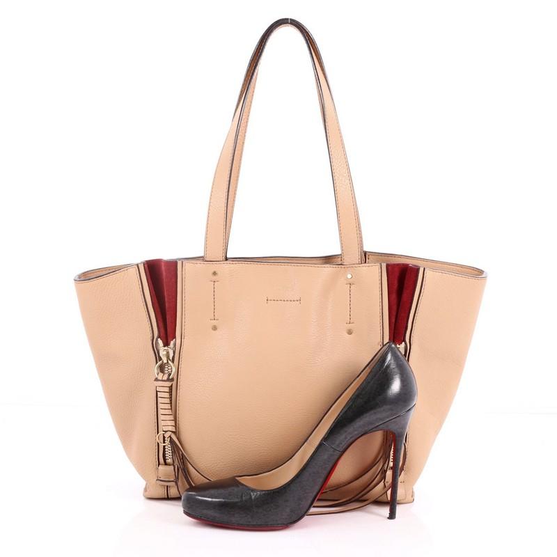 This authentic Chloe Milo Shopping Tote Leather Small is a perfect bag for everyday excursions that's fresh and contemporary for the new season. Crafted from nude leather, this stylish bag features dual flat top handles, contrast suede gussets and