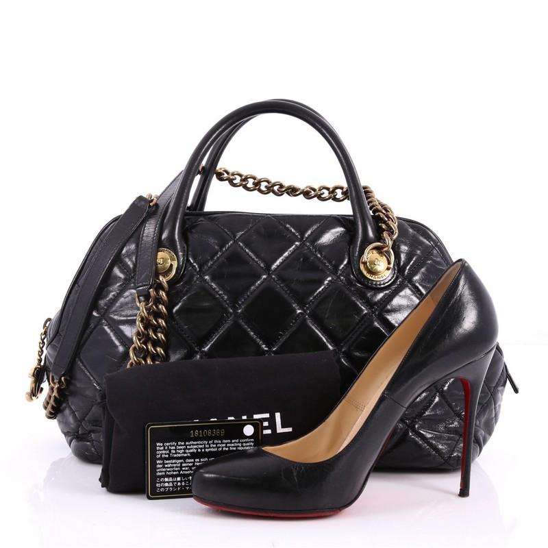 This authentic Chanel Castle Rock Bowler Bag Quilted Glazed Calfskin Medium is one you will love to carry. Crafted from black quilted glazed calfskin, this gorgeous bag features dual-rolled leather top handles, dual chain-link shoulder straps with