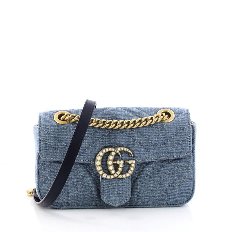 This authentic Gucci Pearly GG Marmont Flap Bag Matelasse Denim Small is a gorgeous and chic bag perfect for your day or nights out. Crafted from matelasse blue denim, this sleek bag features sliding chain strap, flap top with interlocking studded