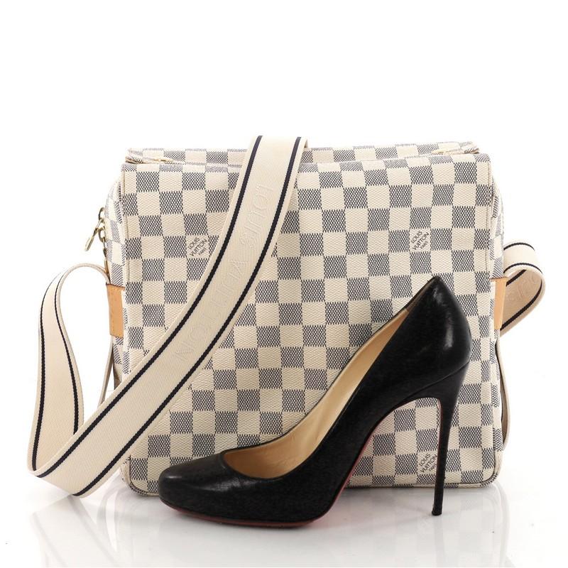 This authentic Louis Vuitton Naviglio Handbag Damier is perfect for the style-conscious man or woman on the go. Crafted from damier azur coated canvas, this elegant bag features a wide canvas adjustable strap, large dual flap design and gold-tone