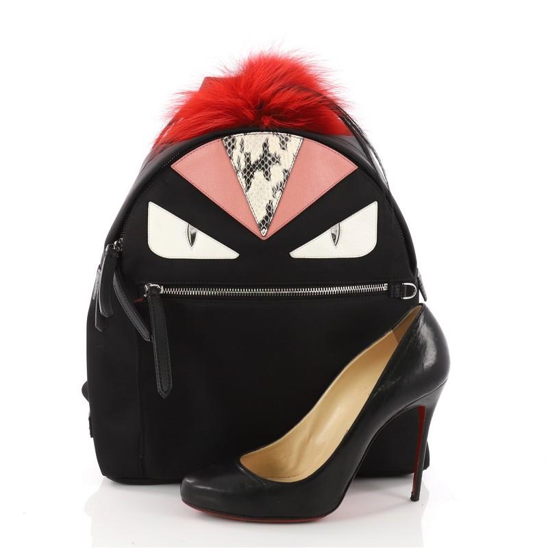 This authentic Fendi Monster Backpack Nylon with Leather and Fur Large balances a luxurious, playful style made for on-the-go fashionistas. Crafted from black nylon, this backpack features Fendi's popular monster design in leather and fur accents, a