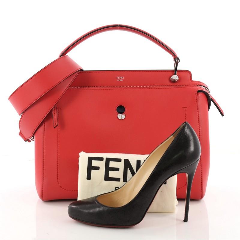 This authentic Fendi DotCom Convertible Satchel Leather Medium is a chic and minimalist bag perfect for your everyday looks. Crafted from red leather, this understated satchel features a flat top handle, removable shoulder strap, distinctive conical