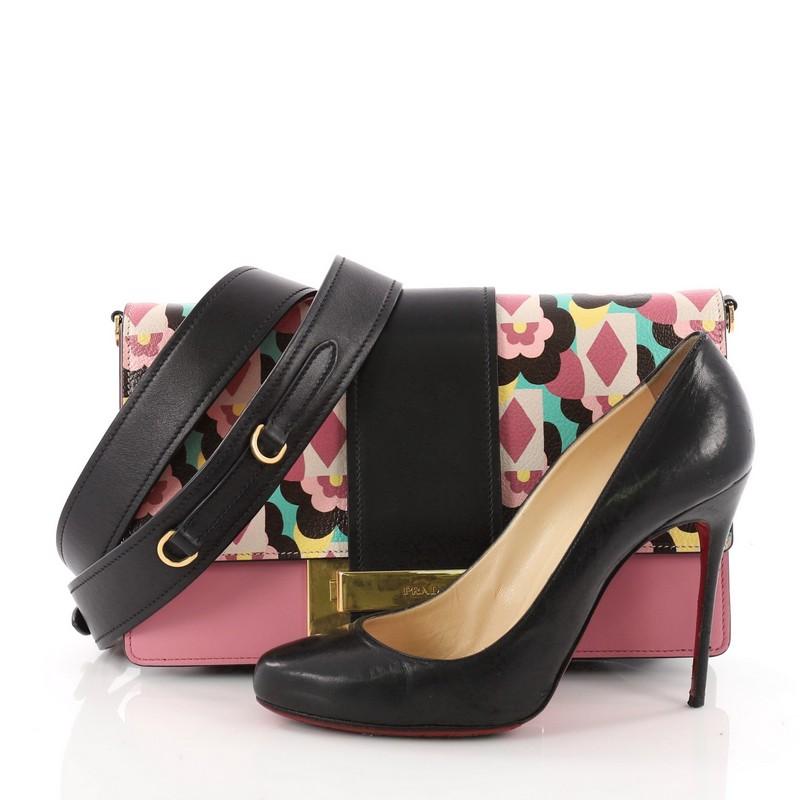 This authentic Prada Metal Ribbon Shoulder Bag Printed Leather Medium is a stylish and unique bag perfect to add to your collection. Crafted in pink floral printed leather, this convertible bag features a removable shoulder strap, flap top with