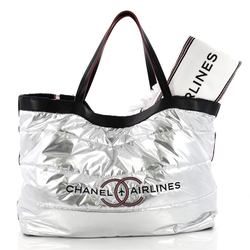 This authentic Chanel Airlines Reversible Tote Terry Cloth Large is a unique tote perfect for your daily excursions. Crafted in navy blue terry cloth and quilted silver metallic fabric on the reverse, this stylish bag features dual flat leather