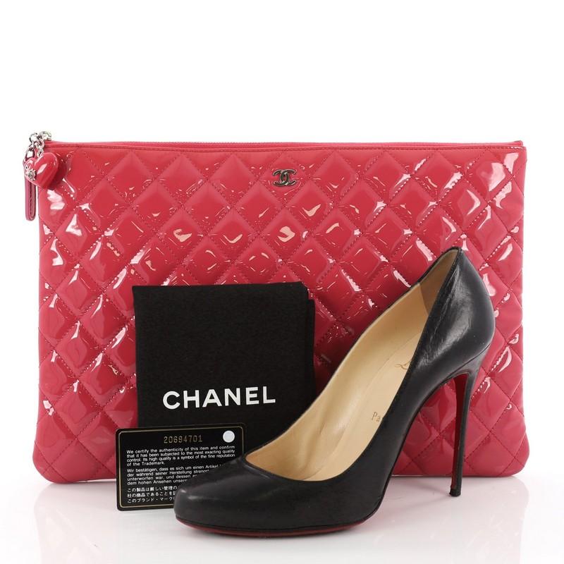 This authentic Chanel Valentine Hearts O Case Clutch Quilted Patent Large is a limited edition bag from the brand's Valentine's Day collection. Crafted from pink quilted patent leather, this clutch features heart charm with a ladybug detail on