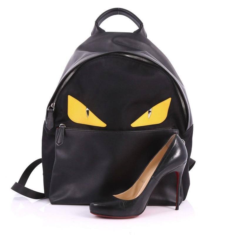 This authentic Fendi Monster Backpack Nylon Large balances a luxurious, playful style made for on-the-go fashionistas. Crafted from black nylon, this backpack features monster eye applique design, a flat top handle, padded adjustable shoulder