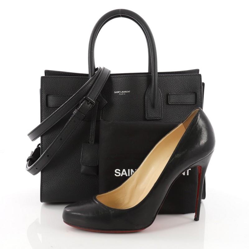 This authentic Saint Laurent Sac de Jour NM Handbag Leather Baby is a sleek yet elegant bag synonymous with the brand's classic aesthetic. Crafted from black leather, this sought-after structured tote features dual-rolled leather handles, classic