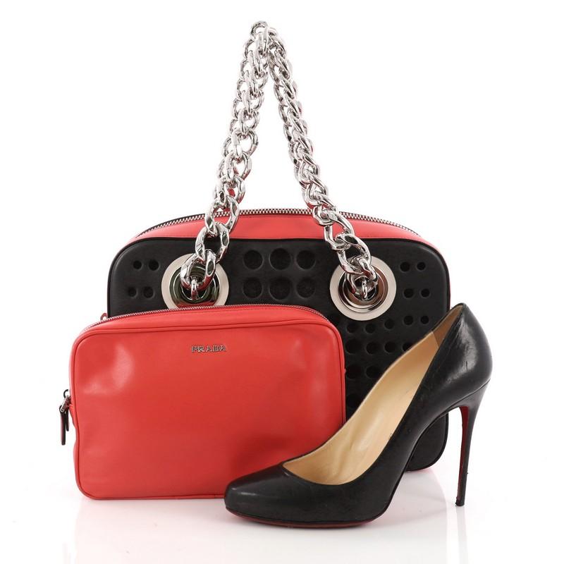 This authentic Prada City Fori Chain Shoulder Bag Perforated Calfskin Small is a delightfully playful bag. Crafted in black and red perforated calfskin leather, this chic bag features dual chunky chain-link handles and silver-tone hardware accents.