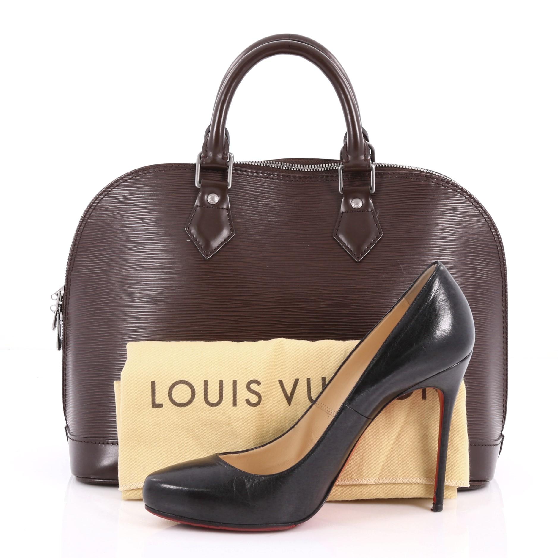 This authentic Louis Vuitton Alma Handbag Epi Leather PM is elegant and classic. Constructed from Louis Vuitton's signature brown epi leather, this iconic bag features dual rolled handles, a sturdy reinforced base, standout contrast stitching, a