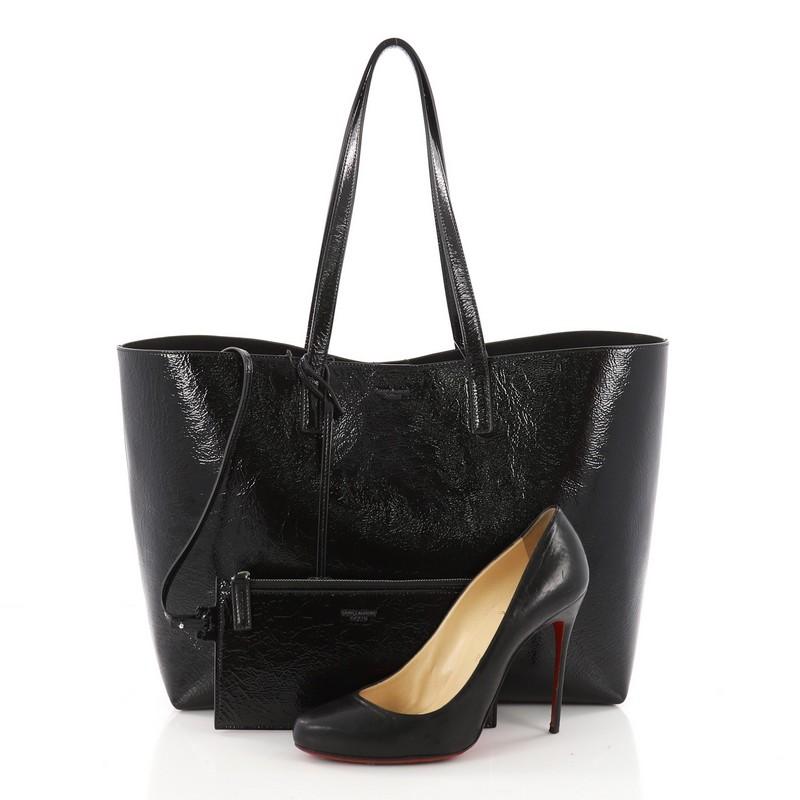 This authentic Saint Laurent Shopper Tote Leather Large showcases the brand's sleek and contemporary design perfect for everyday use. Crafted from black patent leather, this versatile tote features dual-flat patent leather handles, stamped logo at