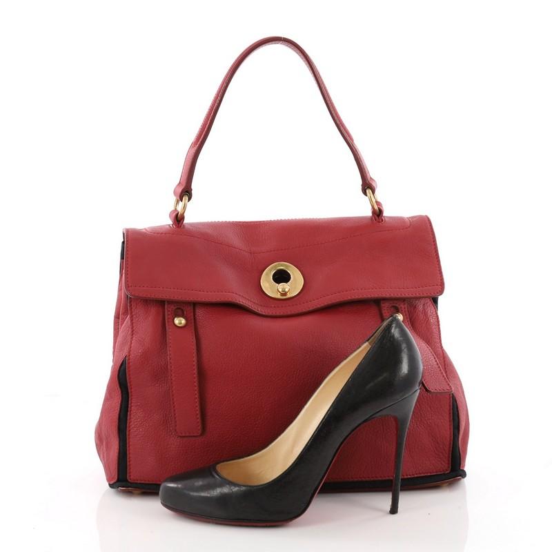This authentic Saint Laurent Muse Two Handbag Leather with Canvas Medium mixes simple design and details. Crafted in red leather with black canvas, this subtle minimalist tote features a single looped top handle, protective base studs and gold-tone