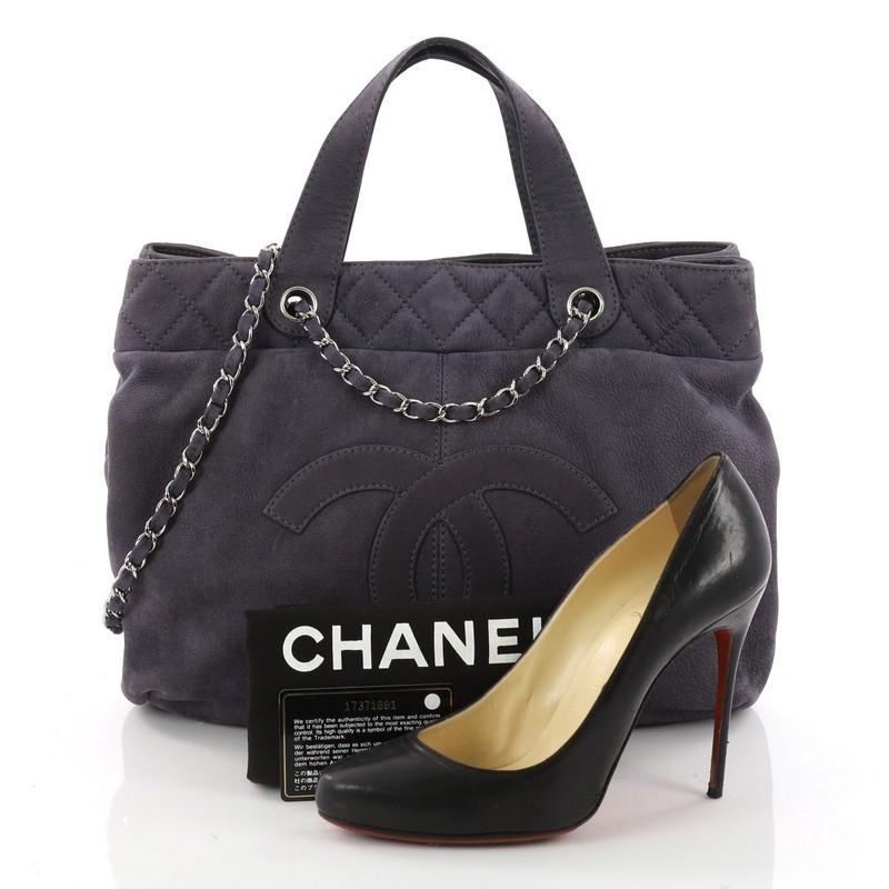 This authentic Chanel Trianon Shopping Tote Nubuck Large is a chic tote ideal for everyday use. Crafted in blue nubuck, this stylish bag features woven-in leather chain straps, dual flat top handles, stitched CC logo at front and silver-tone