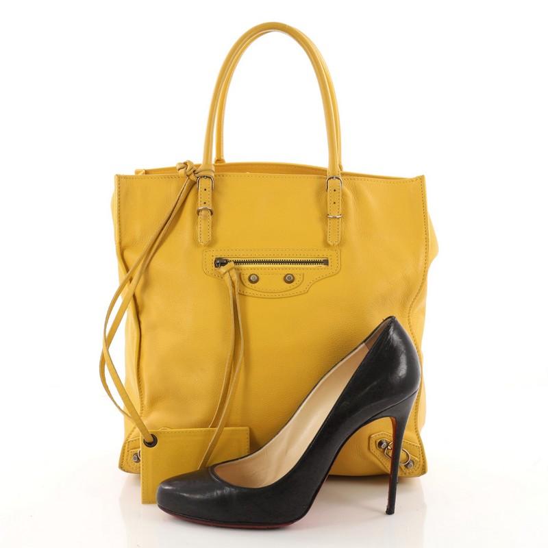 This authentic Balenciaga Papier A5 Classic Studs Handbag Leather Medium combines the brand's easy-chic style with luxurious flair. Crafted from beautiful yellow leather, this lightweight, easy tote features dual-rolled handles with buckle details,