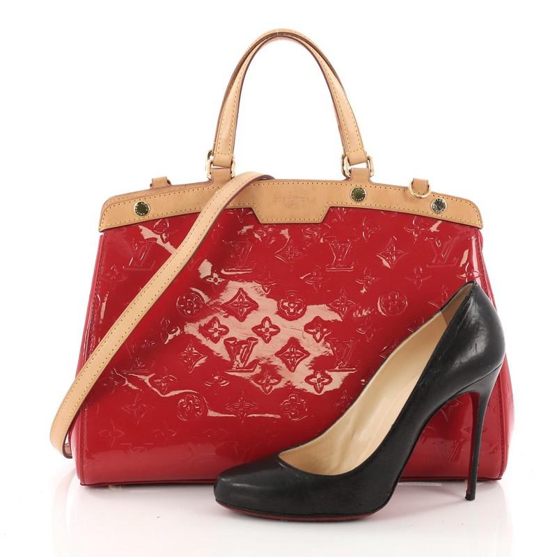 This authentic Louis Vuitton Brea Handbag Monogram Vernis MM is a staple for an everyday casual look. Crafted in red monogram vernis leather with cowhide leather trims, this structured yet feminine tote features dual flat handles, protective base