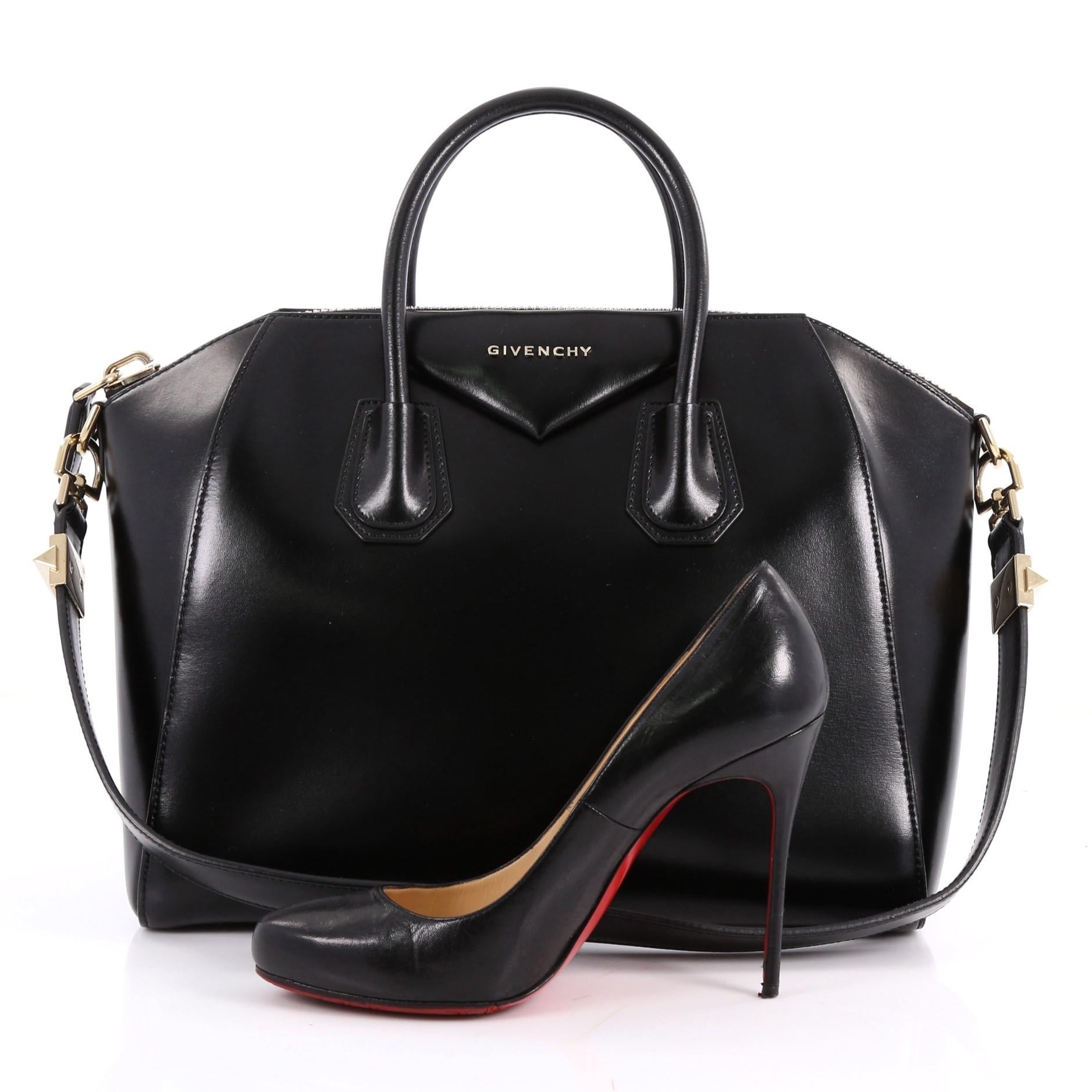 This authentic Givenchy Antigona Bag Glazed Leather Medium combines style and functionality all-in-one. Crafted from sleek black glazed leather, this structured handle bag features a dual-rolled leather handle, the brand's signature envelope flap