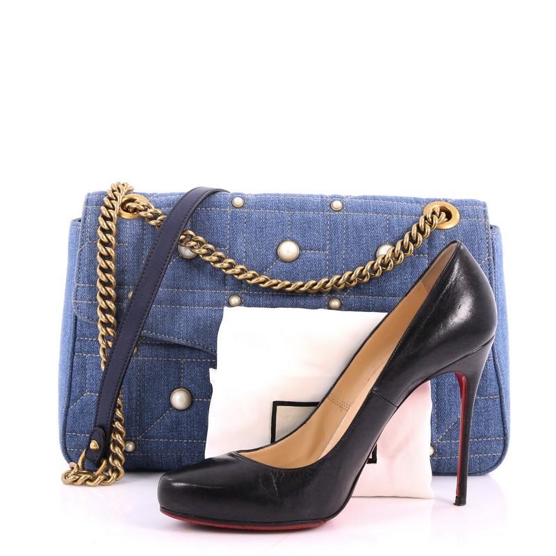 This authentic Gucci Pearly GG Marmont Flap Bag Embellished Matelasse Denim Medium is a gorgeous bag perfect for your days or nights out. Crafted from blue matelass̩e denim with a cubic pattern enhanced with metal and pearl studs, this sleek bag