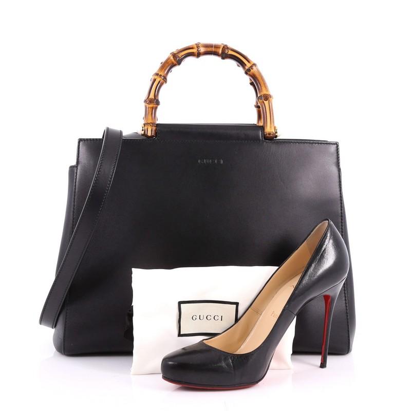 This authentic Gucci Nymphaea Tote Leather Medium is a stylish bag perfect for the modern fashionista. Crafted in black leather, this gorgeous bag features a leather shoulder strap, bamboo handles with pearls, and gold-tone hardware accents. Its