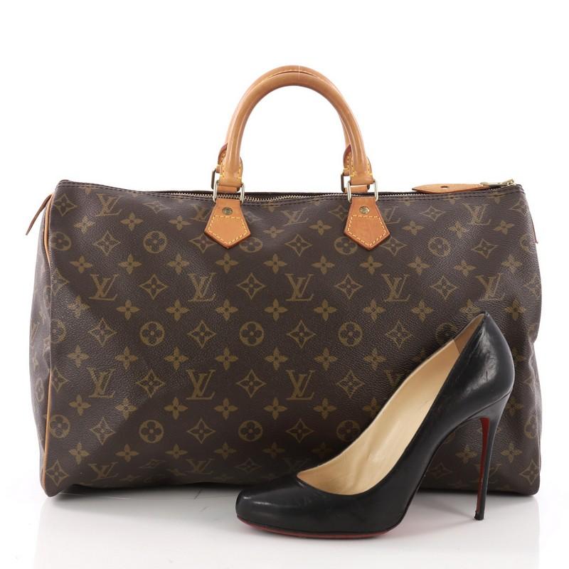 This authentic Louis Vuitton Speedy Handbag Monogram Canvas 40 is spacious and light, making it ideal to use everyday. Constructed in Louis Vuitton's classic brown monogram coated canvas, this iconic Speedy features dual-rolled leather handle,