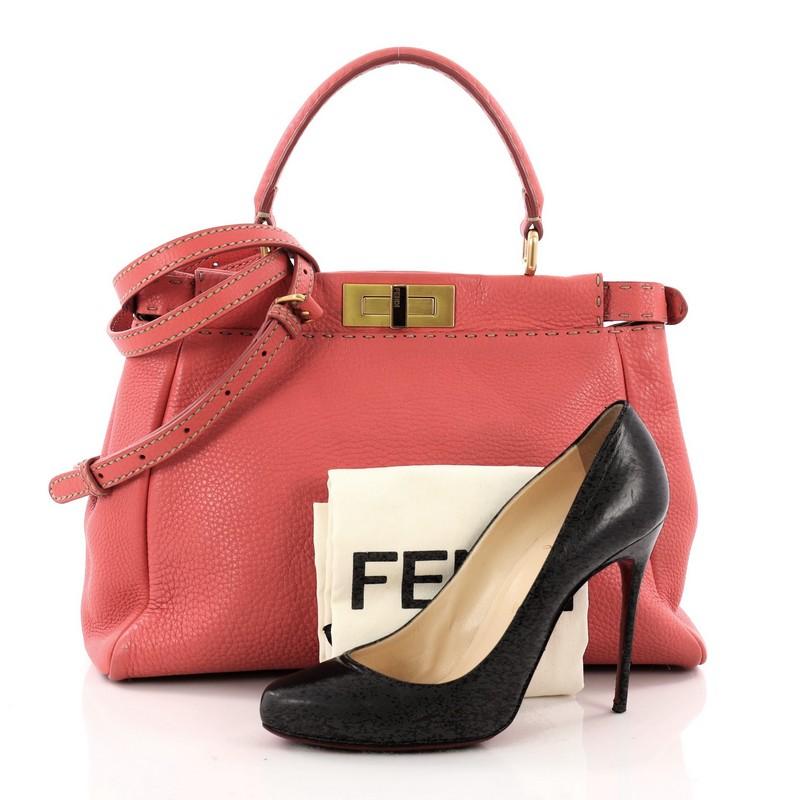 This authentic Fendi Selleria Peekaboo Handbag Leather Regular is a stand-out, carry-all piece updating its classic Peekaboo style. Crafted from luxurious pink leather with subtle contrast stitching, this stylish tote features a short leather top