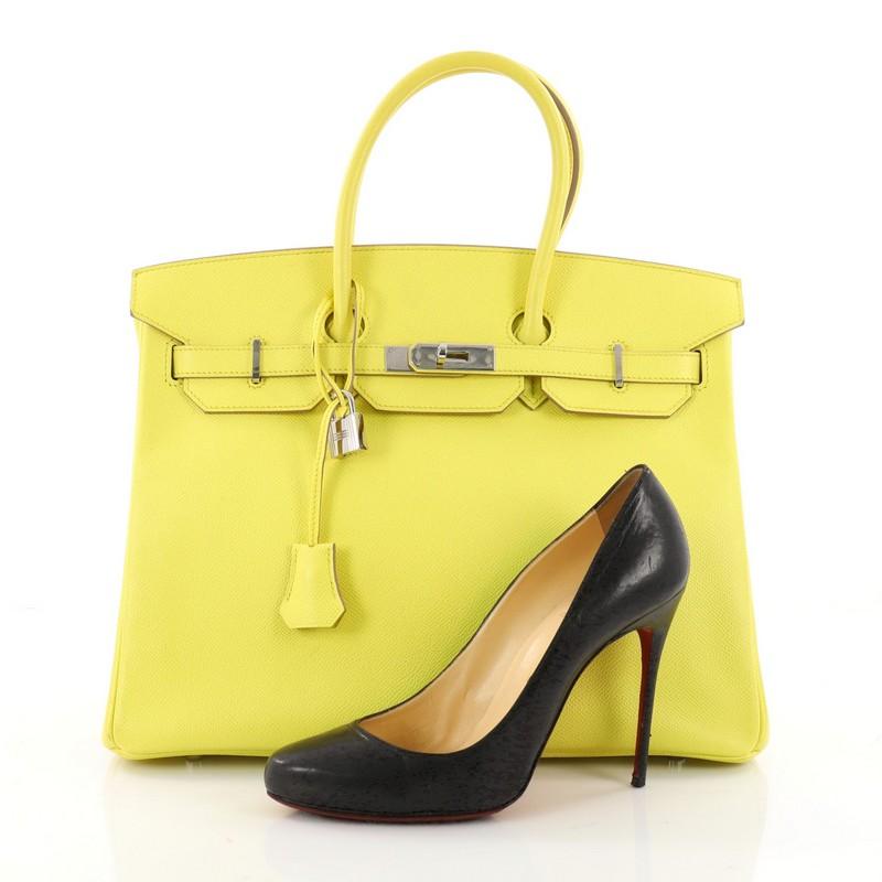 This authentic Hermes Birkin Handbag Yellow Epsom with Palladium Hardware 35 is synonymous to traditional Hermes luxury. Crafted with sturdy, scratch-resistant  Soufre yellow epsom leather, this eye-catching tote features dual-rolled top handles, a